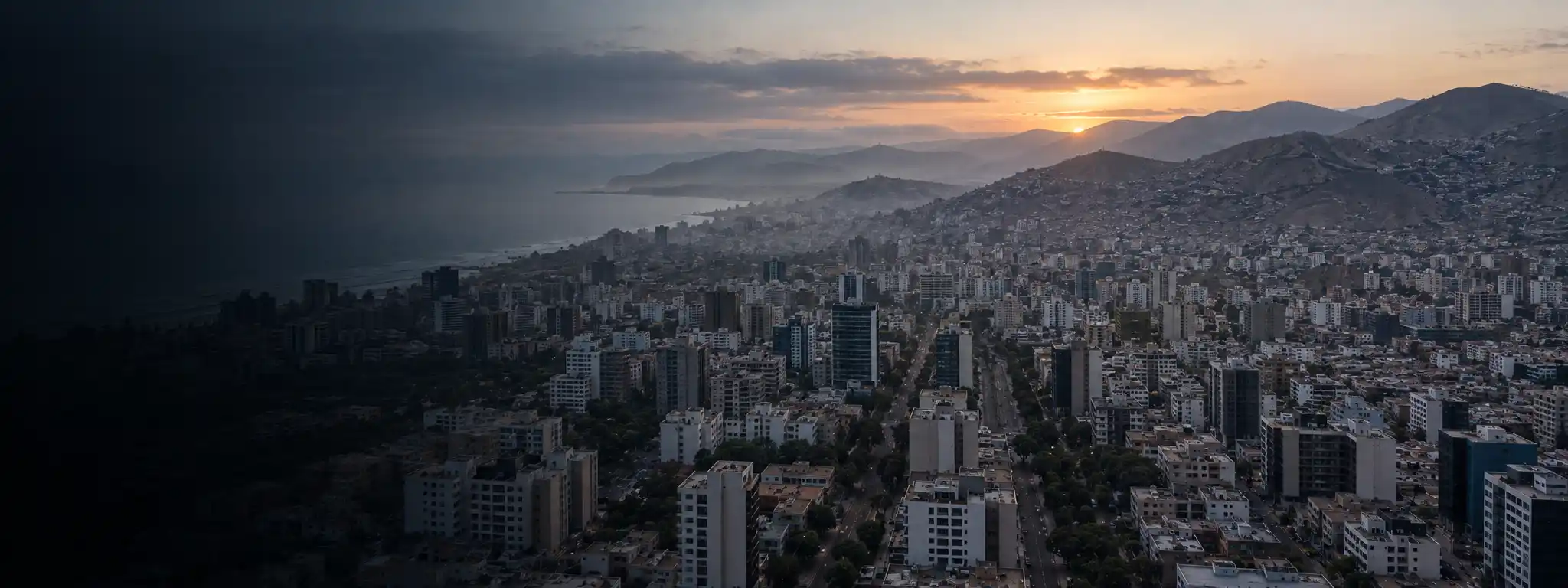Vista aérea de una ciudad latinoamericana al amanecer, con edificios modernos y barrios en ladera al fondo